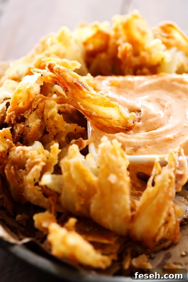 Blooming Onion with Dipping Sauce... This is such an incredible appetizer. The flavor of the battered onion combined with the sauce makes for one addictive and unforgettable recipe!