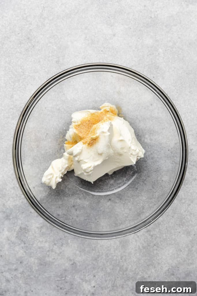 Cream cheese in a bowl with garlic powder and salt.