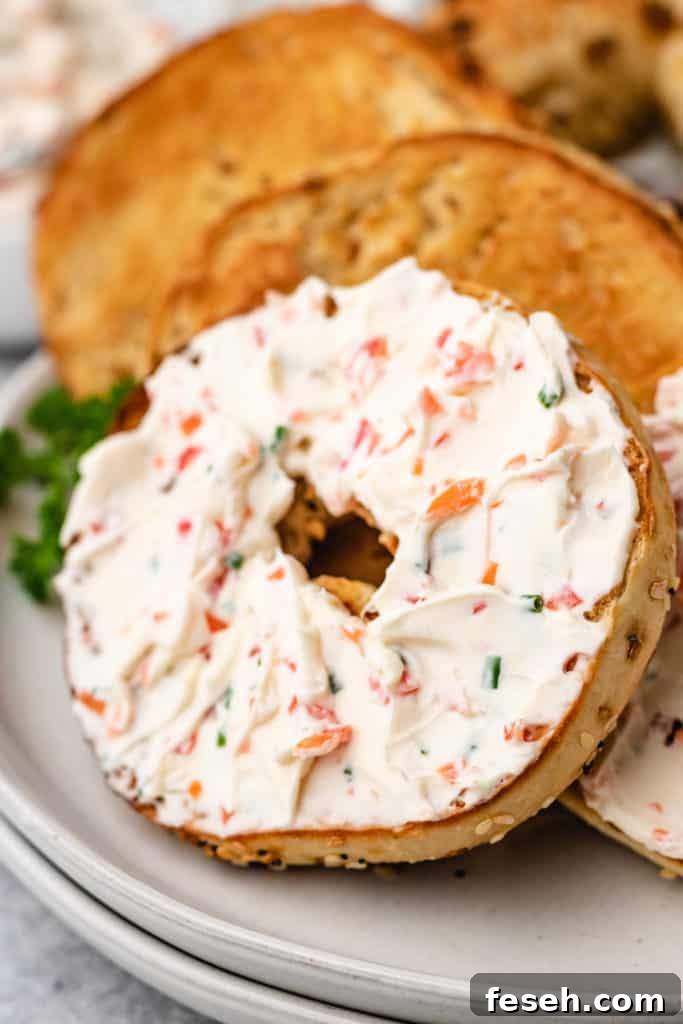 Close up view of an everything bagel with cream cheese.