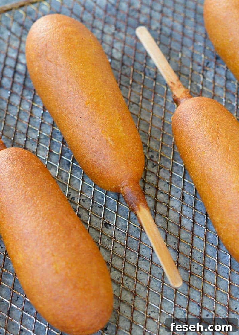 several crispy corn dogs on an air fryer rack