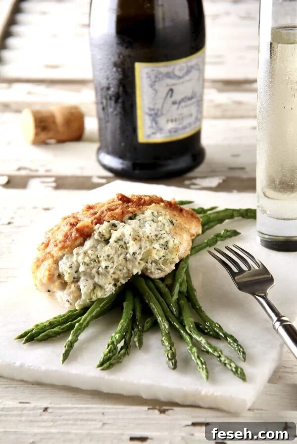 One serving of Crab-Stuffed Chicken Breasts over asparagus on thin piece of marble.