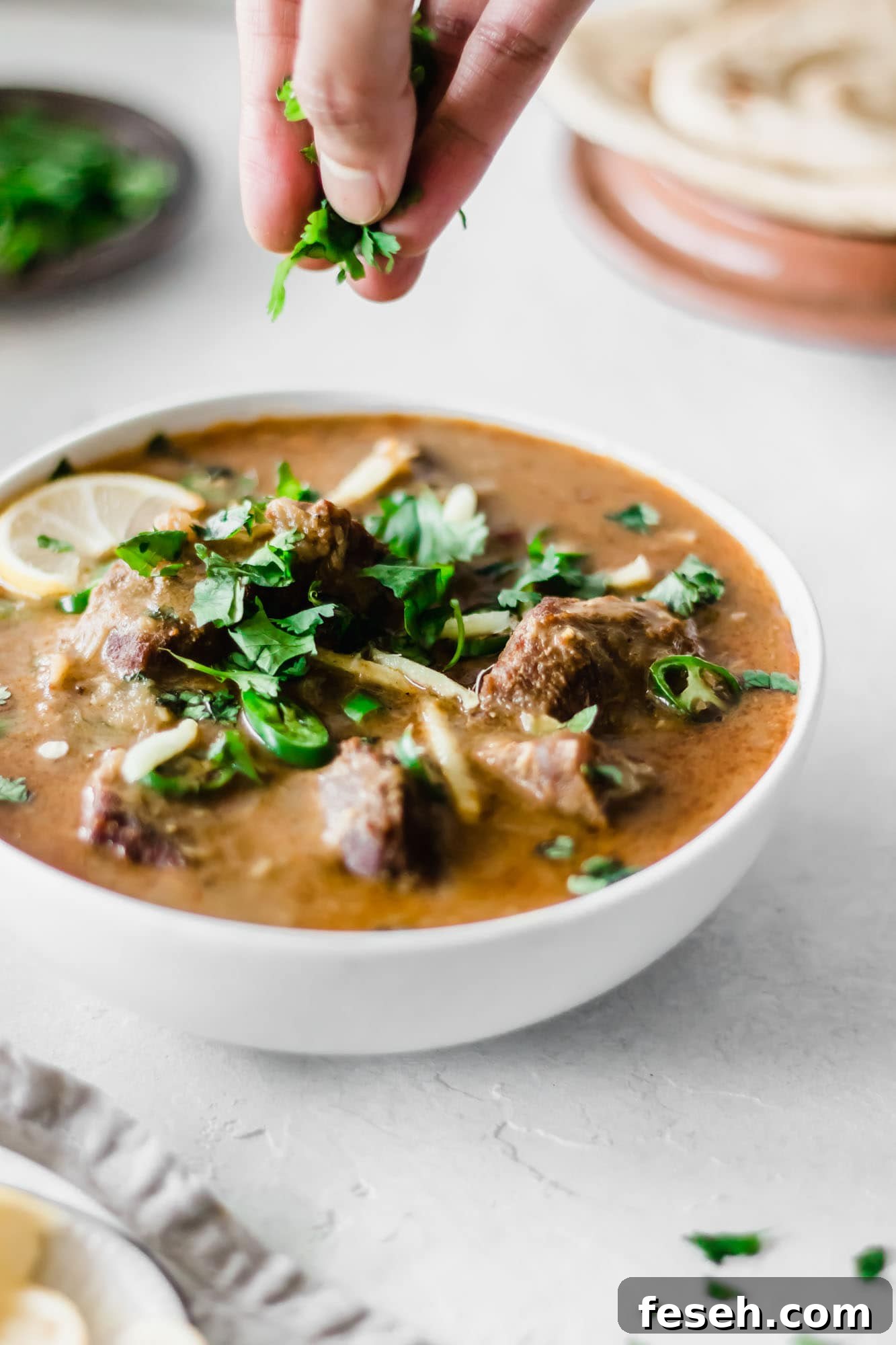 Garnishing a bowl of Instant Pot Nihari with cilantro.