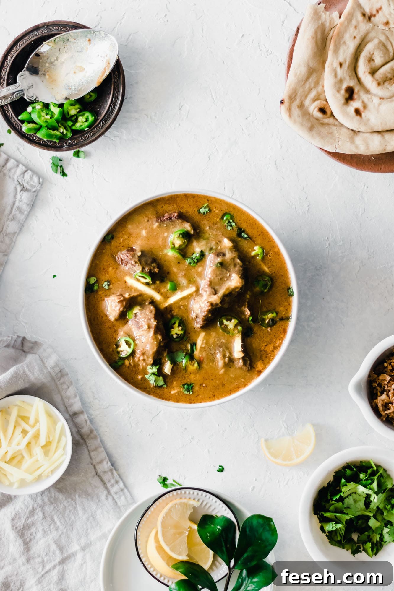 Top view of a bowl of Instant Pot Nihari garnished with cilantro, green chilies and ginger.