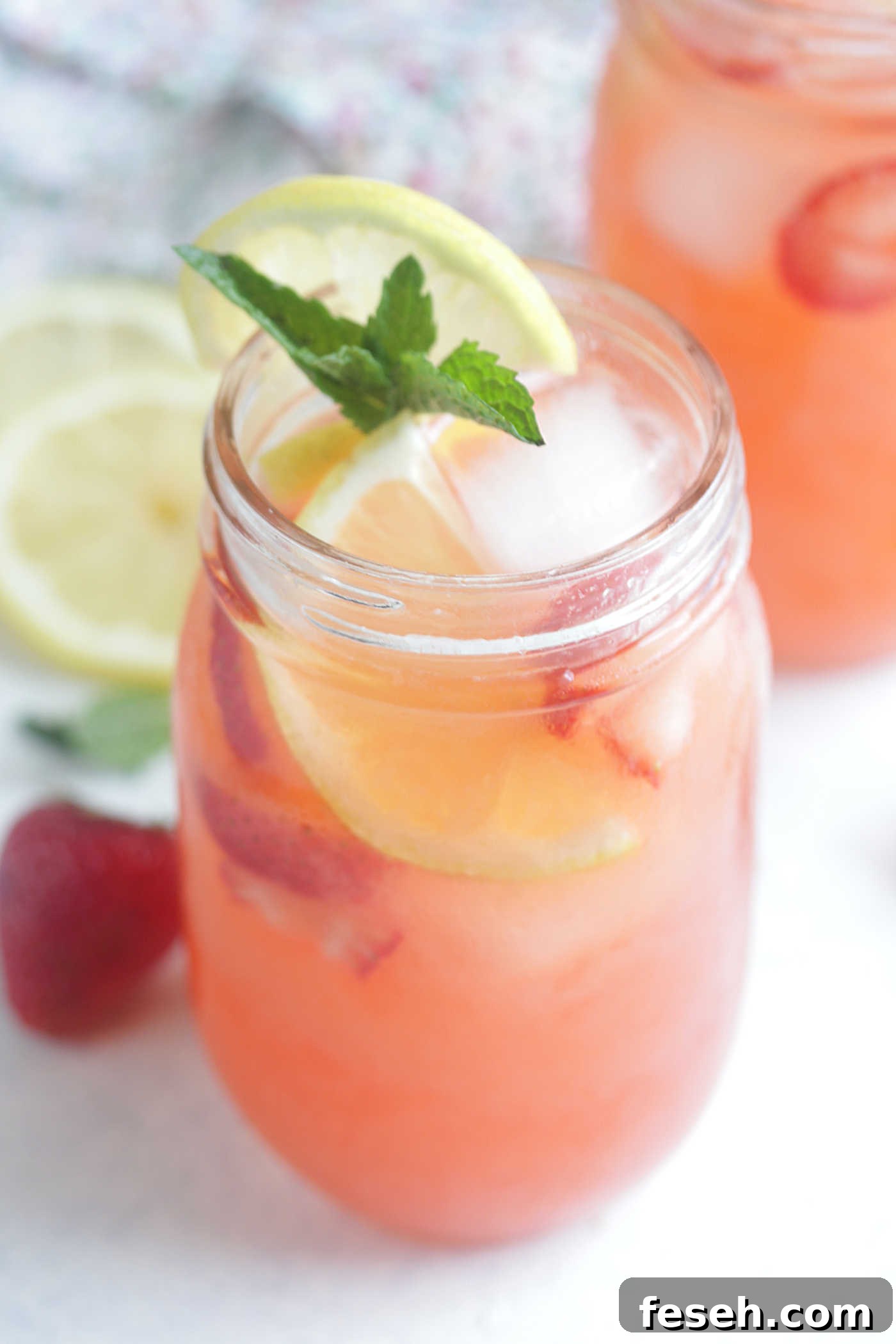 Close up shot of strawberry lemonade spritzers with fresh strawberries and lemon juice