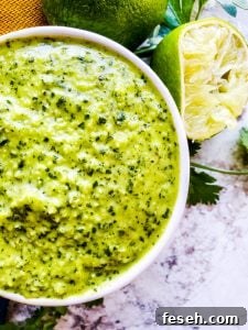 Close up overhead shot of sauce in a white bowl with lime next to it.