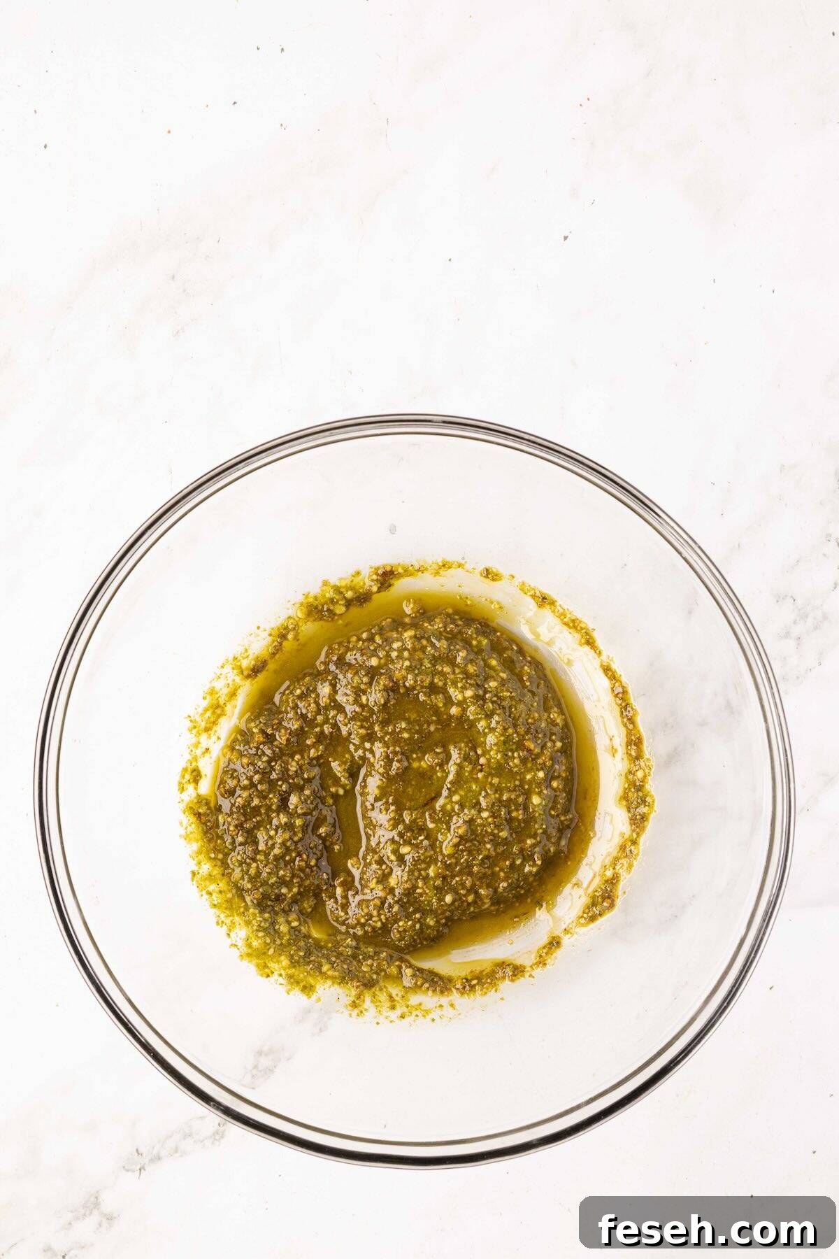 A mixture of pesto and balsamic glaze in a bowl.