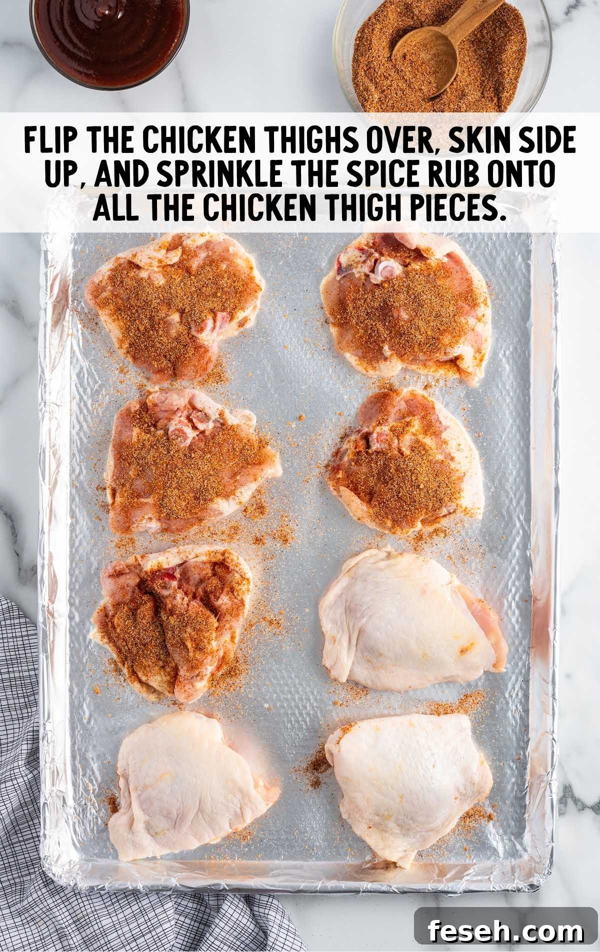 spice rub coated on top of the chicken thighs in a baking dish