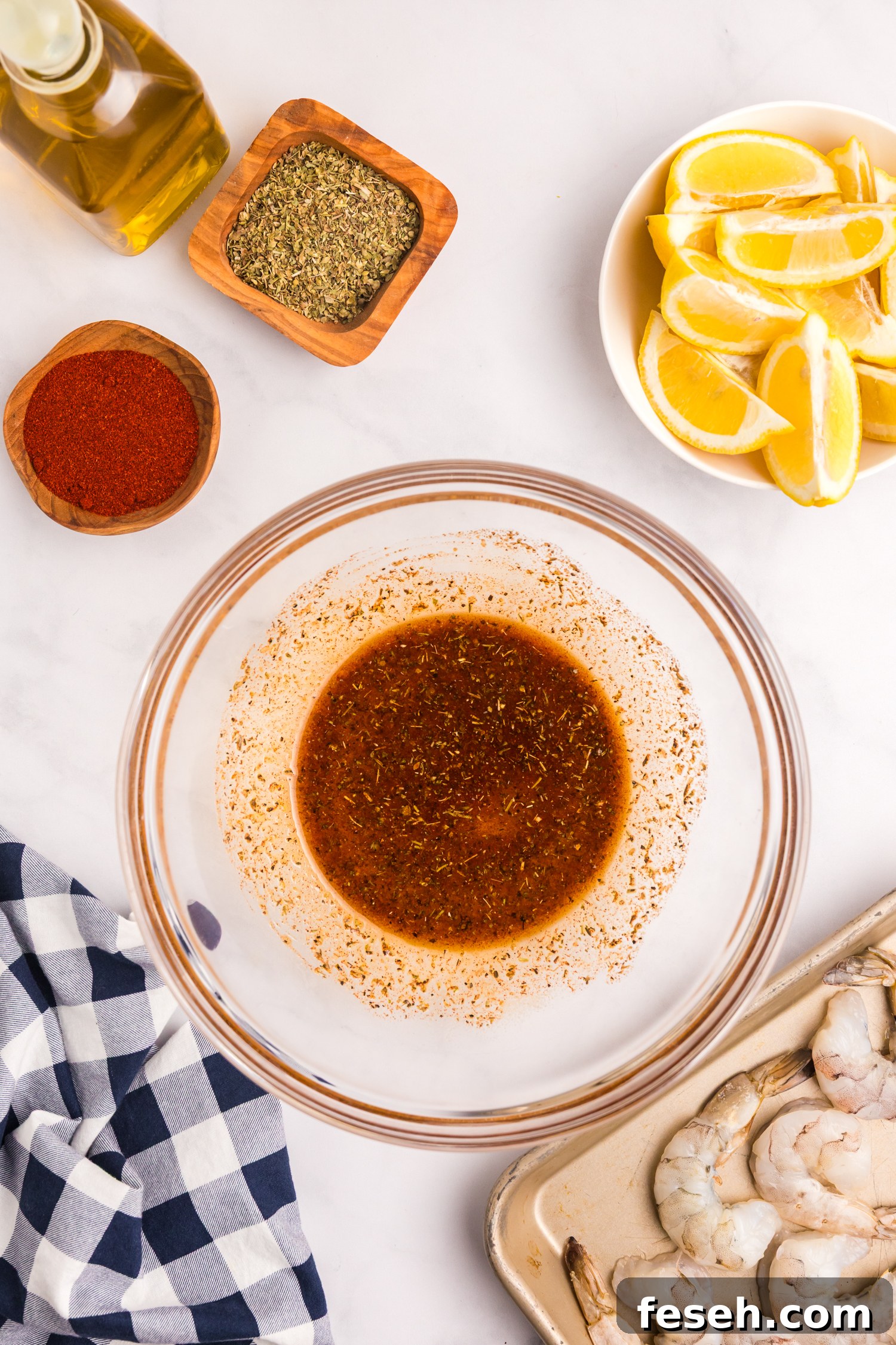 The spice mixture in the glass bowl fully combined into a marinade with a deep reddish-brown color.