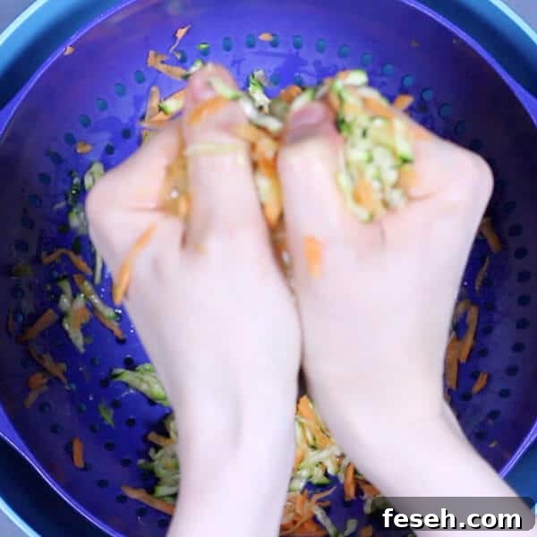 hands squeezing shredded carrot and zucchini