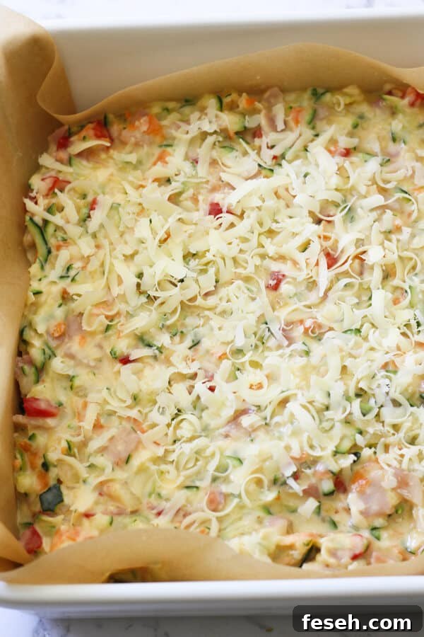 Zucchini and Bacon Slice ingredients in a baking tray ready for the oven. 