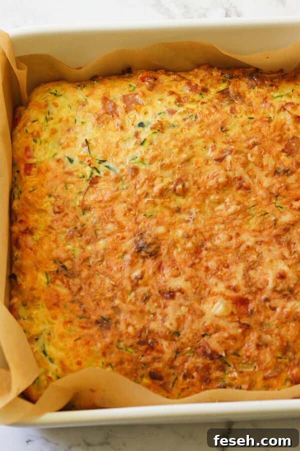 Zucchini and Bacon Slice in a baking tray just out of the oven. 