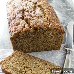 A slice of whole wheat banana bread next to a knife.