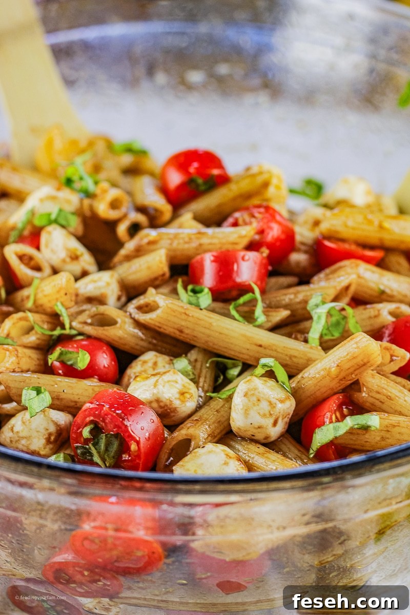 pasta salad made with sliced tomatoes and cucumbers with a balsamic dressing