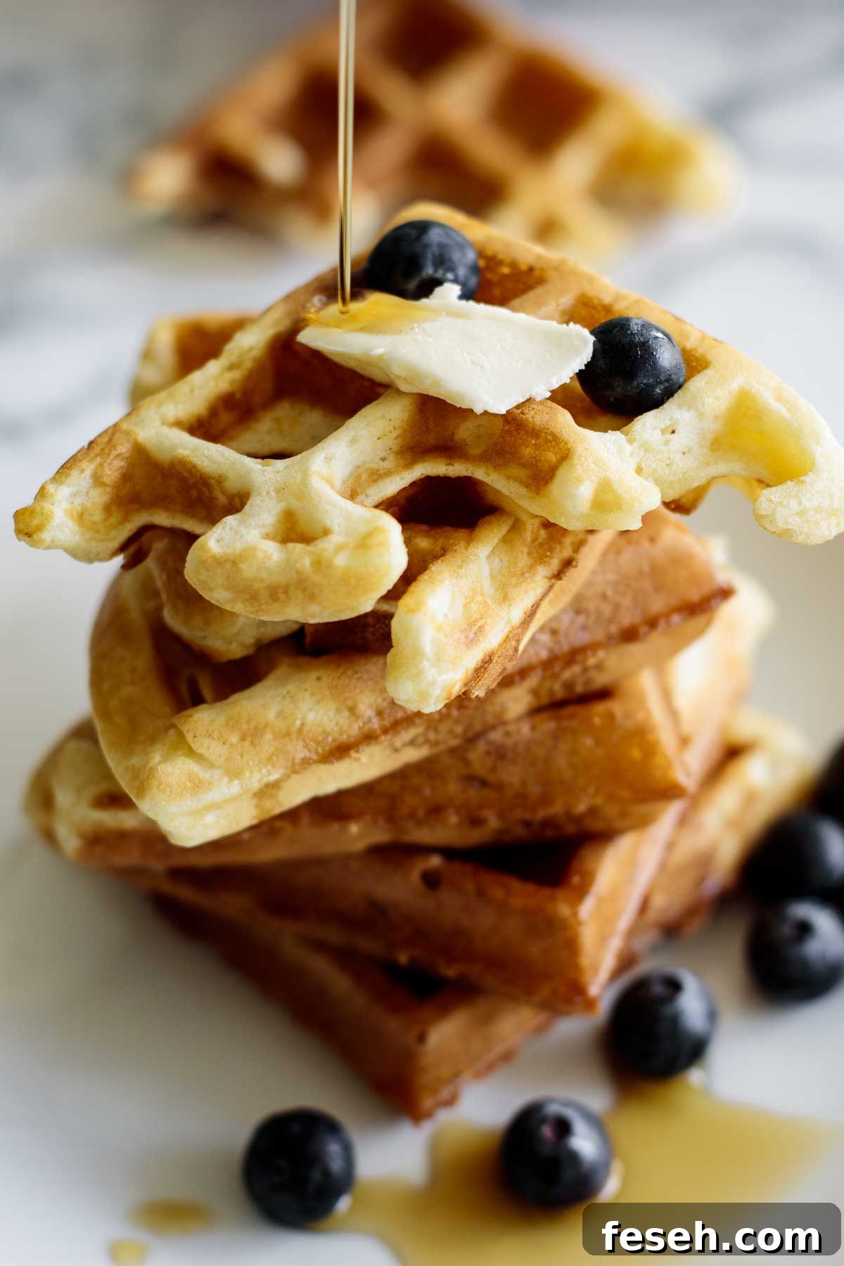 Waffles with berries, maple syrup and butter.