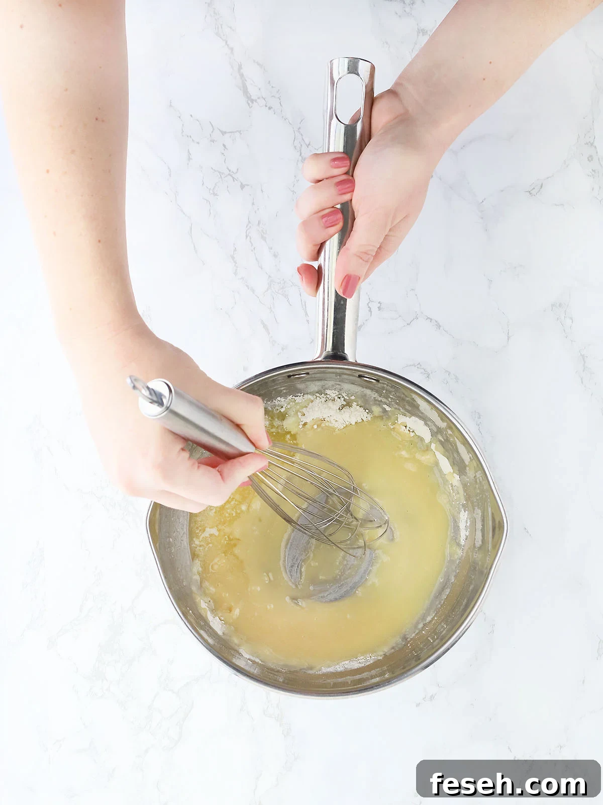 hand whisking flour into melted butter