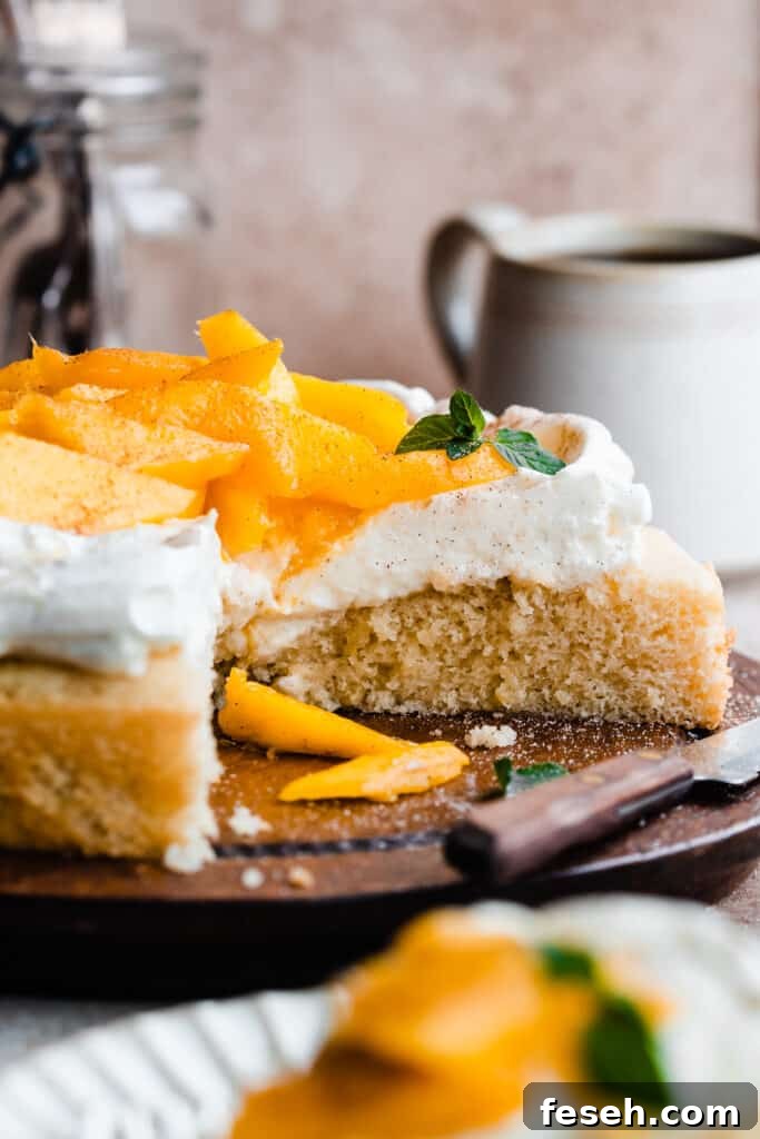 The sliced open mango cake on a wooden cake plate.