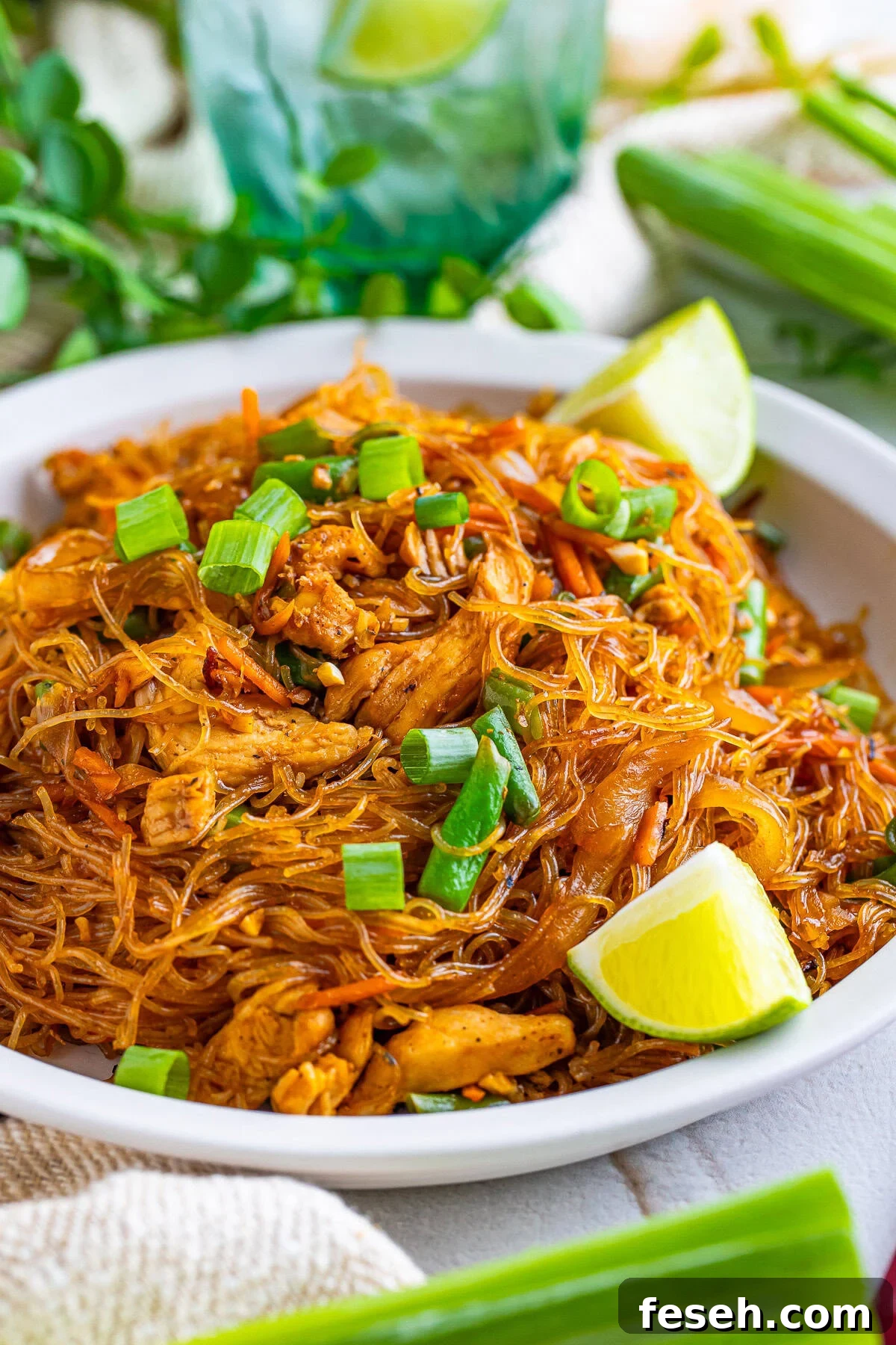 finished Pancit on a white plate with limes