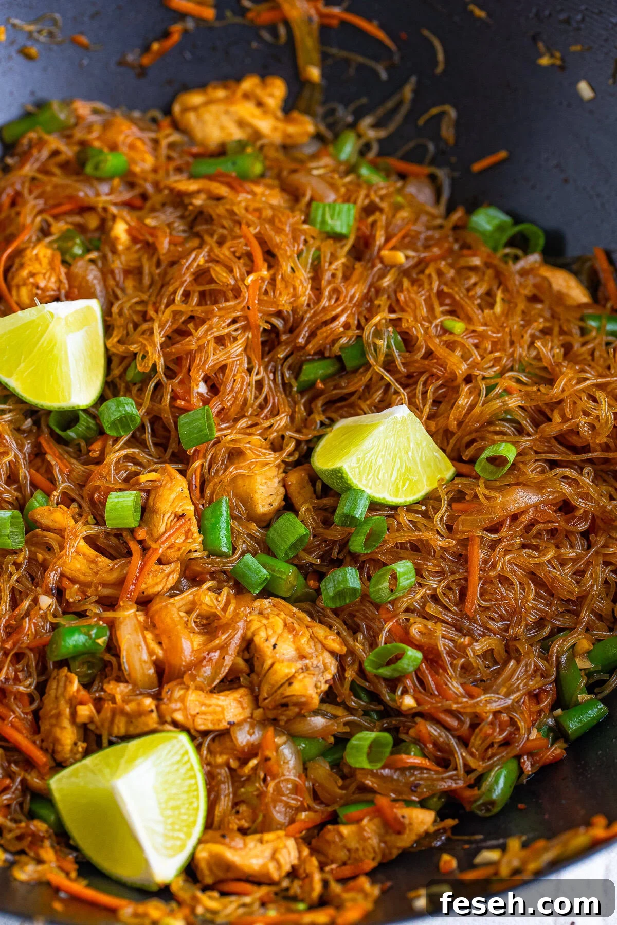 Pancit in a woke with limes