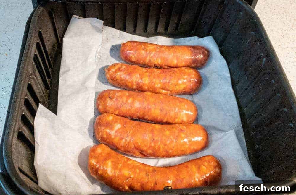 Crispy Juicy Italian Sausage in the Air Fryer 4 Italian sausage in the air fryer on parchment paper