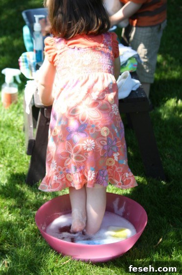 toddler standing in bowl of soapy water