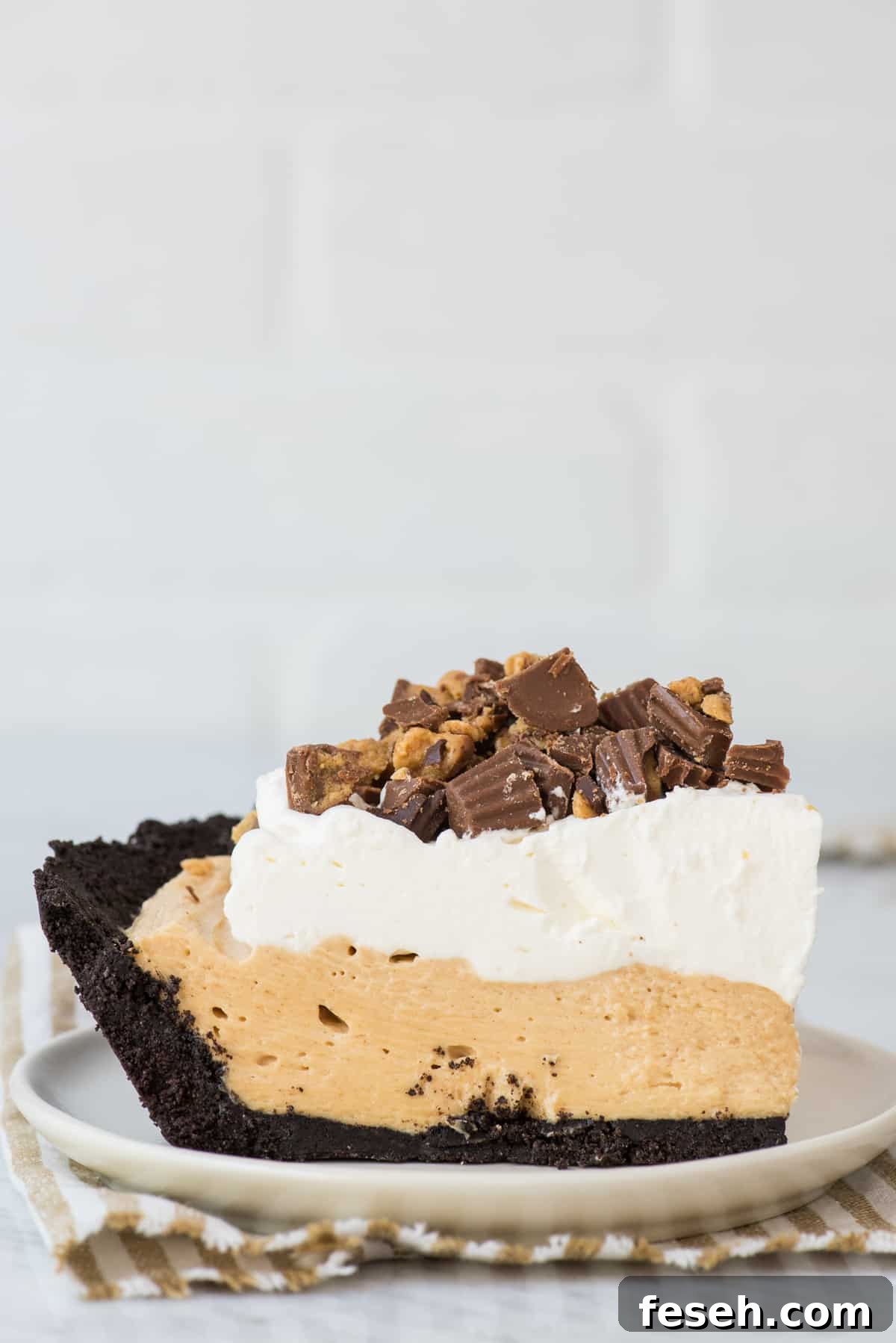 slice of peanut butter pie on white plate with white background