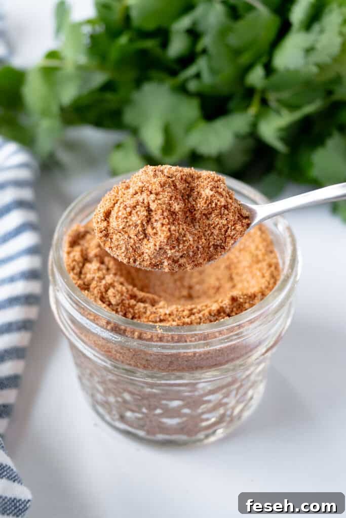 Low Country Cajun Seasoning in a jar with a small spoonful of seasoning.