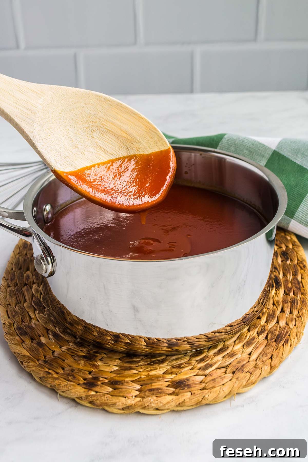 Stirring homemade bbq sauce in a pot.