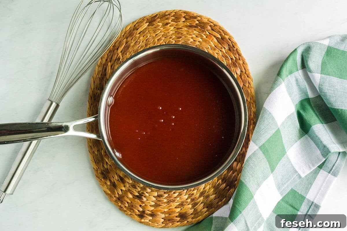 A saucepan of barbecue sauce on a trivet.