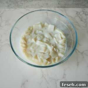 Calamari rings in a bowl covered with buttermilk.