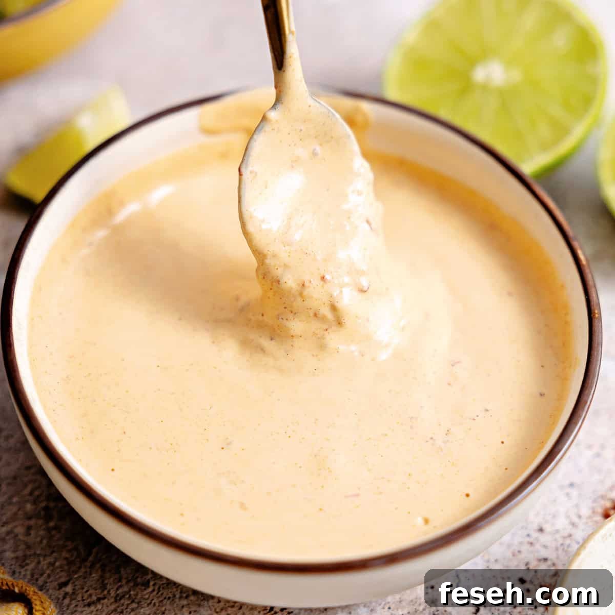 Bowl with chipotle mayo being drizzled with a spoon.