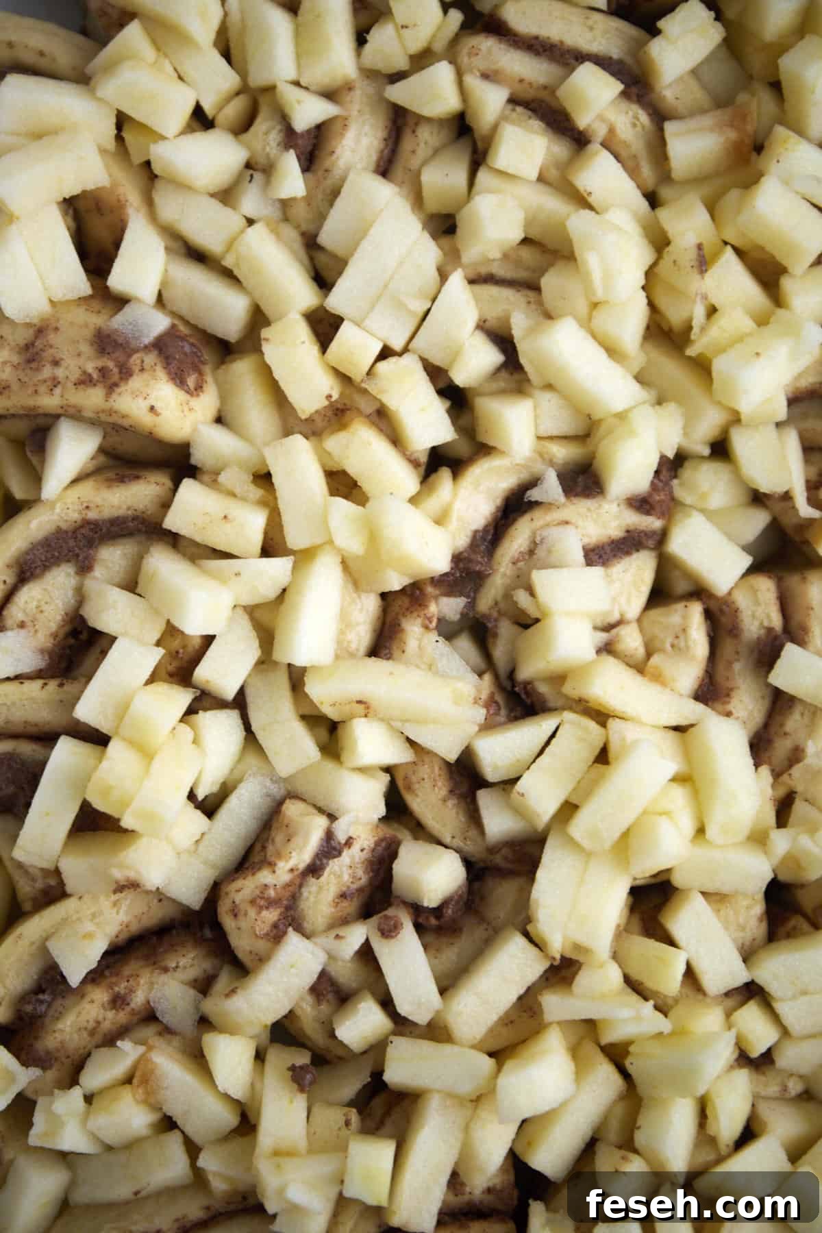 cinnamon roll dough topped with chopped apple pieces