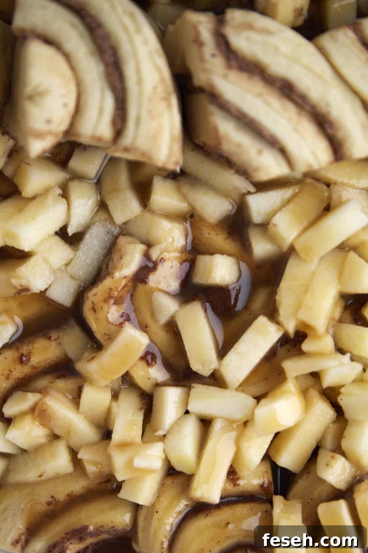 quartered dough topped with apple chunks and caramel 