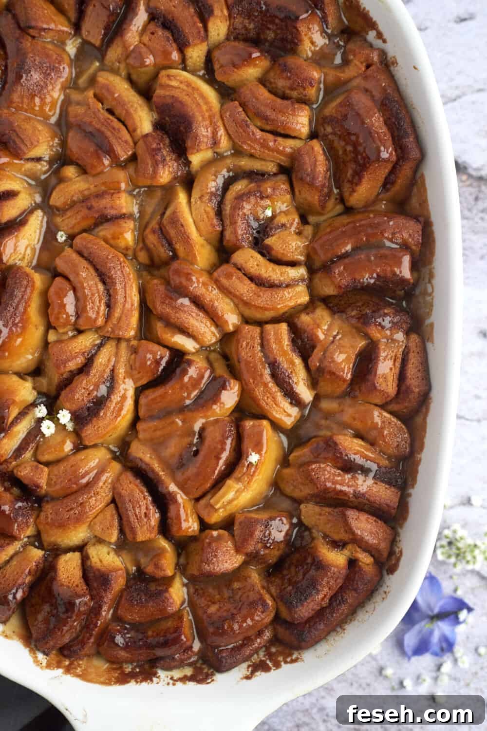 overhead image of a dish full of layered baked apple caramel cinnamon rolls