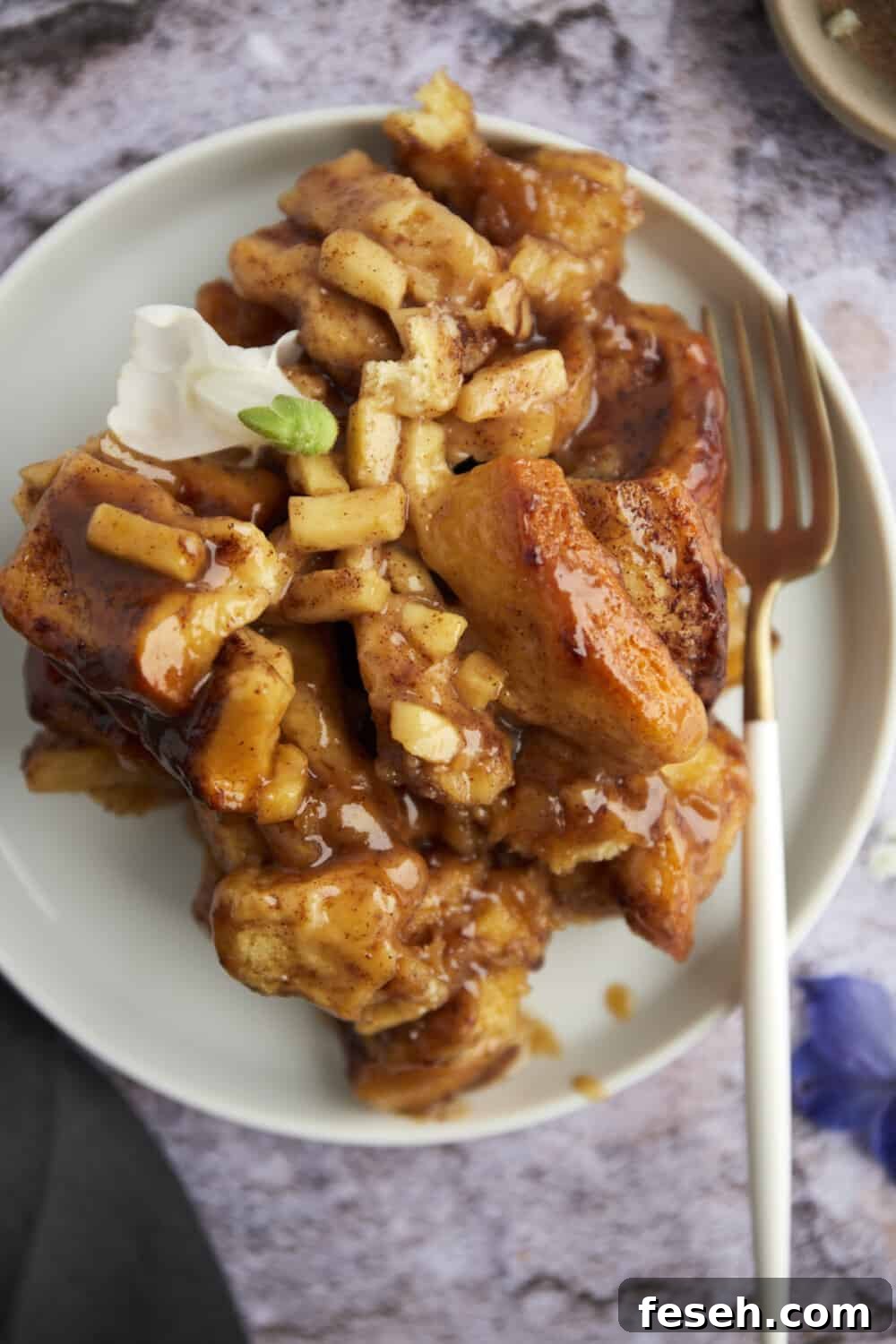 apple caramel cinnamon rolls on a plate with a fork 