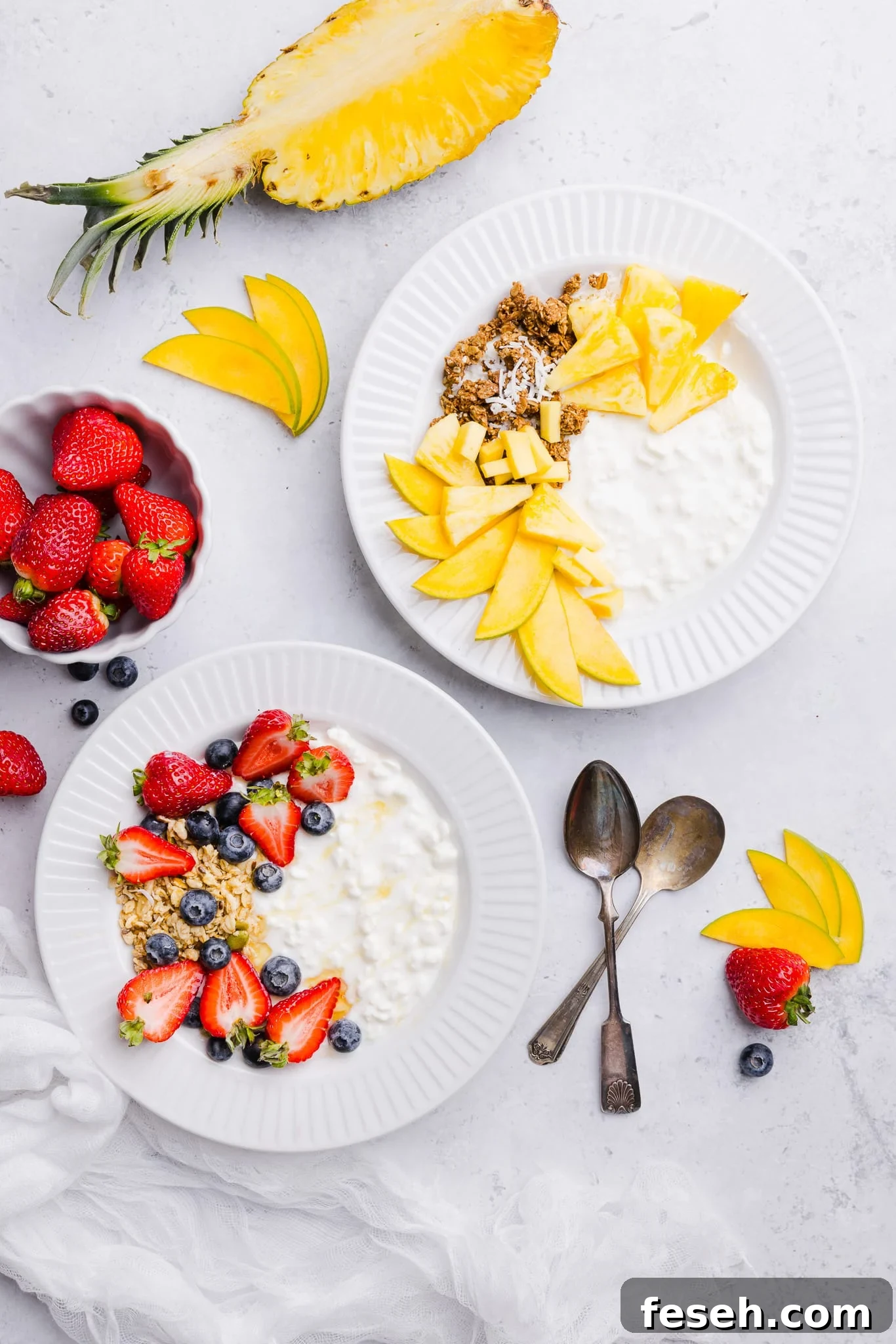 Cottage cheese and fruit bowls with various toppings like berries, granola, pineapple and mango.