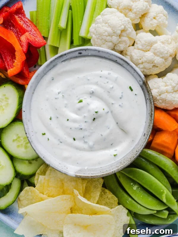 Ranch dip with cottage cheese in a bowl on a vegetable plate with various cut vegetables.