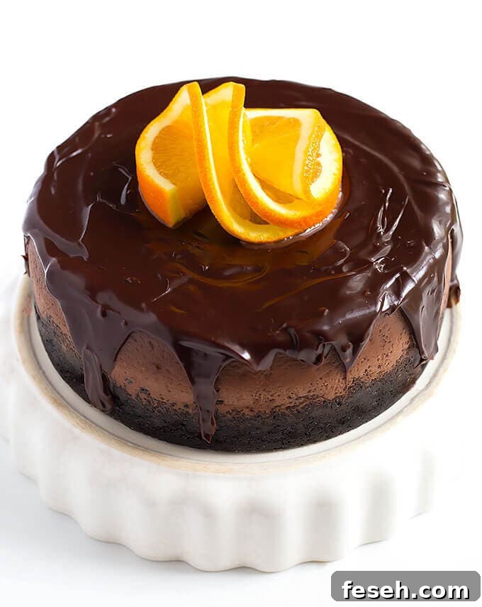 Instant Pot Chocolate Orange Cheesecake on a white serving dish garnished with sliced orange