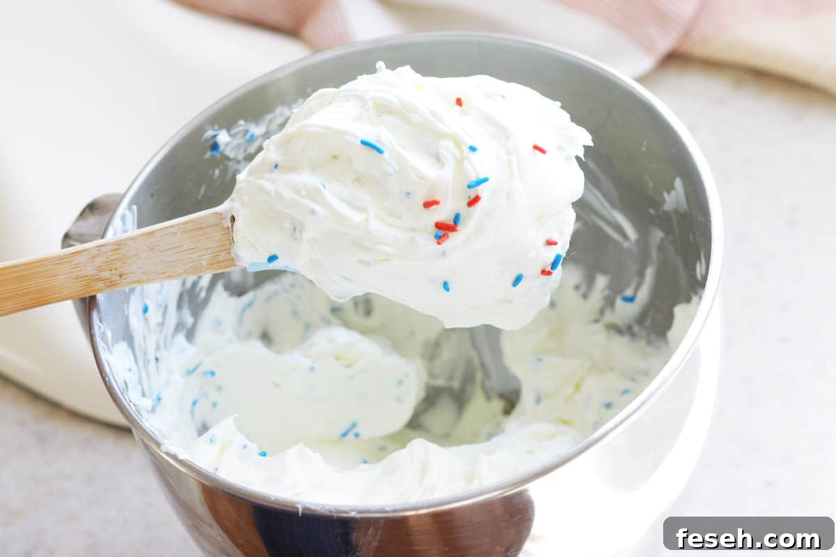 Patriotic 4th of July Icebox Cake Recipe for Summer Parties 5 freshly whipped cream in a kitchenaid mixer bowl with 4th of July sprinkles mixed in