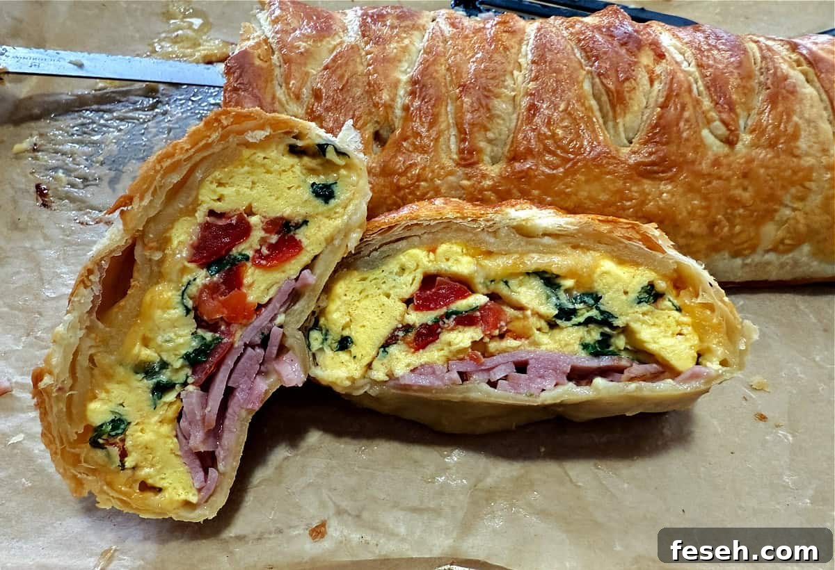 Slices of the breakfast egg bake with the braided puff pastry behind.