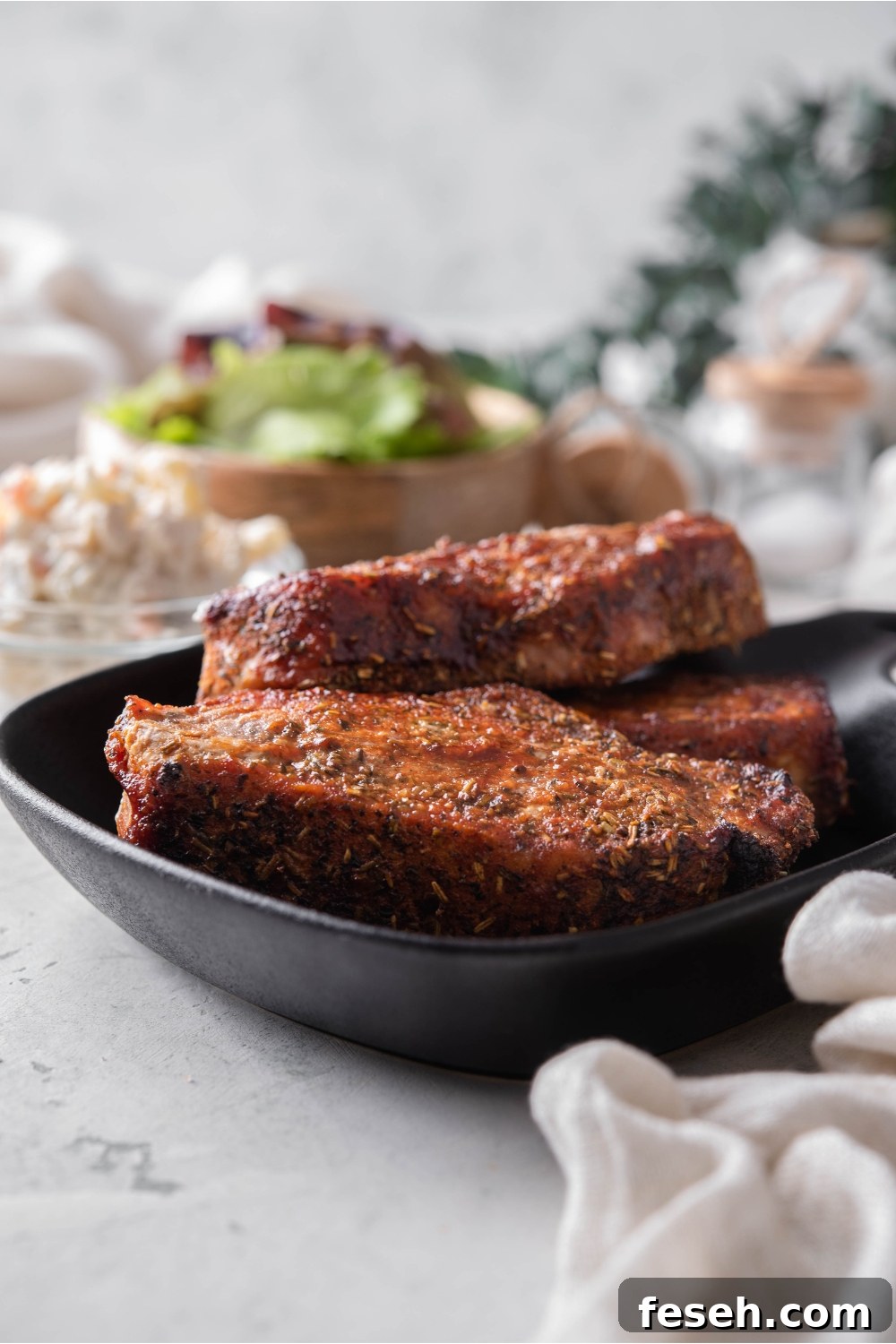 A stack of seasoned boneless ribs on a black plate.