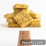 Pile of zucchini slice on a marble and wood cake stand.