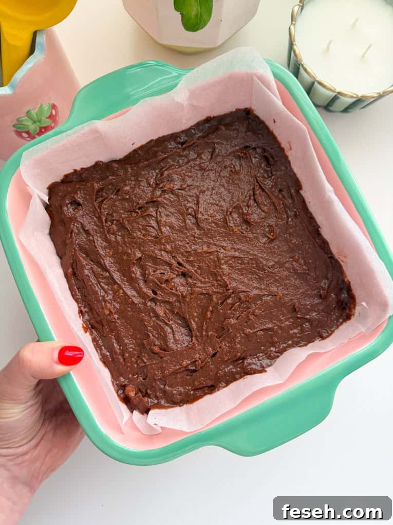 Lined brownie dish with mixture added.
