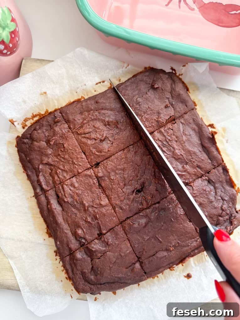 Brownie slab being cut into equal squares.