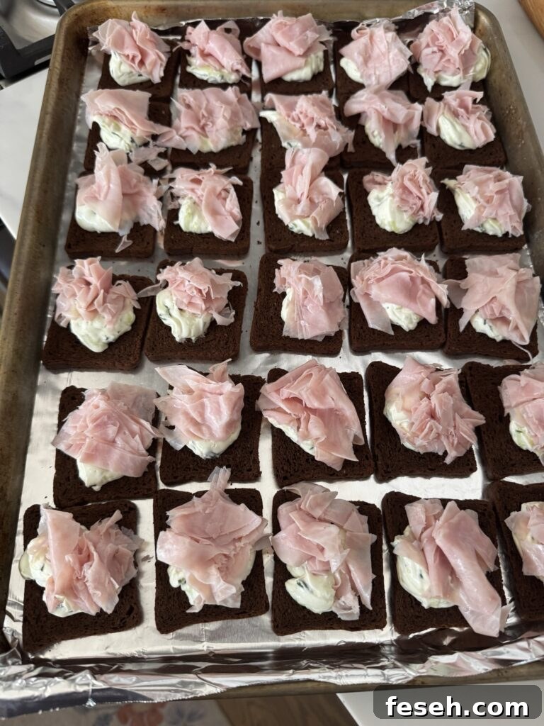 Shaved ham on top of cucumber cream cheese toasts