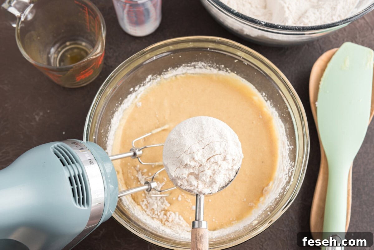 adding flour mixture to wet ingredients in a bowl