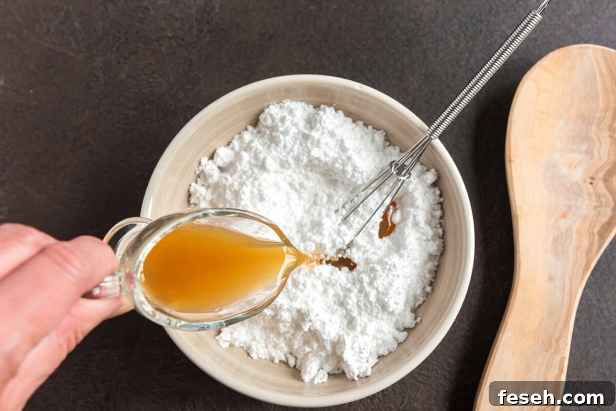 pouring apple cider into powdered sugar