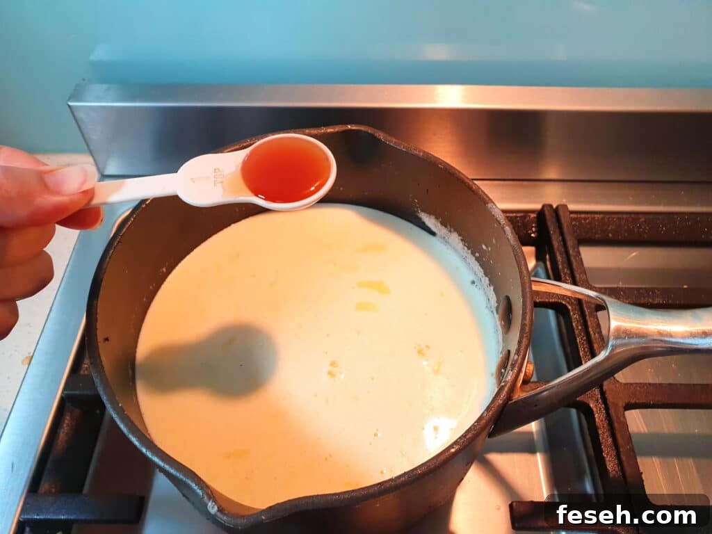 adding vanilla to ice cream mix in pot on stove.