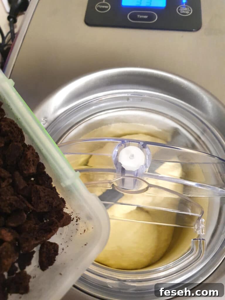 adding crushed up Oreos to ice cream churning in churner.