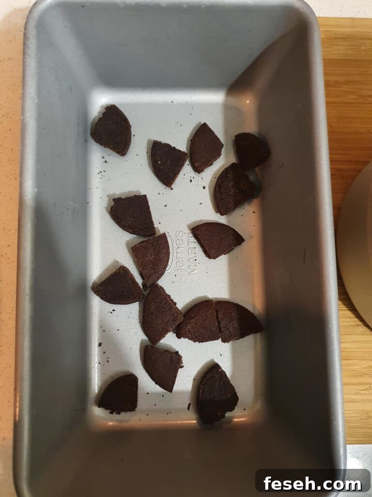 pan with a hand full, or about four cookies quartered and scattered in the bottom.