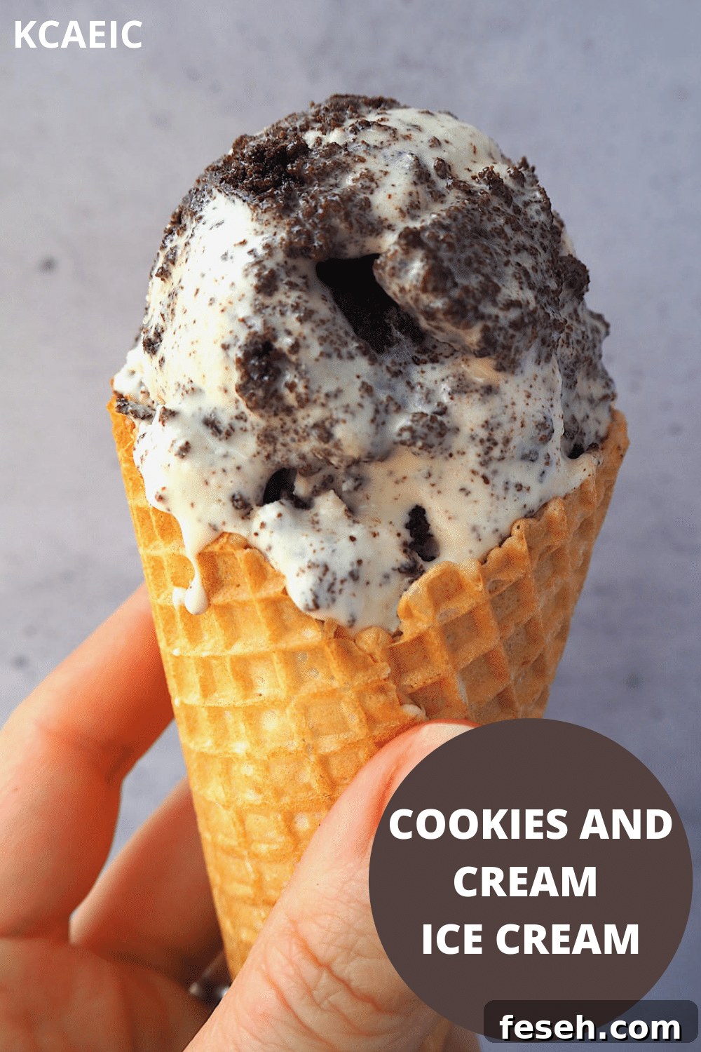 Close up of scoop of cookies and cream ice cream in a waffle cone being held, with text overlay, cookies and cream ice cream, KCAEIC.